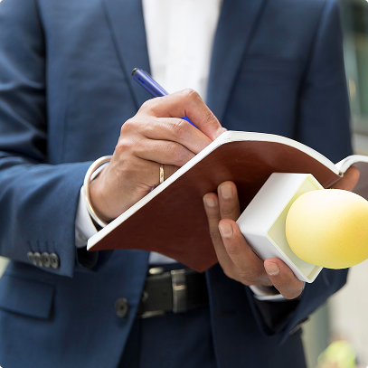 Persona in giacca che prende appunti su un taccuino con un microfono